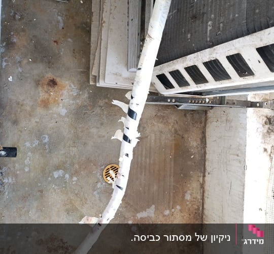מרפסת שירות מוזנחת ומלוכלכת עם מעבה מזגן וצנרת פגומה